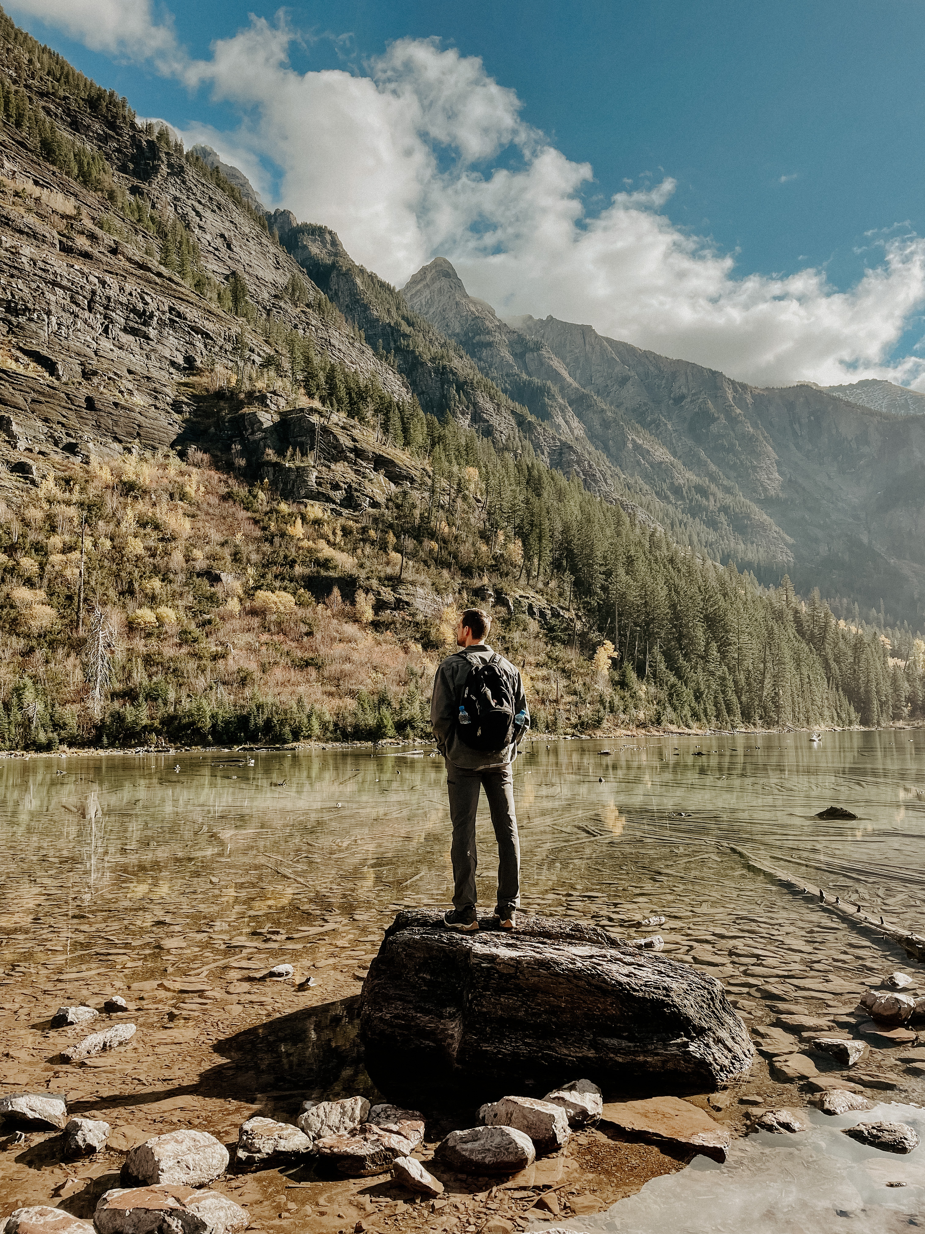 Luke Warner standing by a mountain lake.